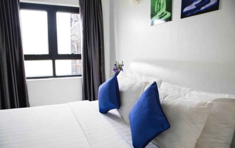 Cozy bedroom with blue pillows and natural light for optimal sleep comfort