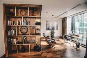 Modern home office with built-in wooden bookshelf and comfortable reading area