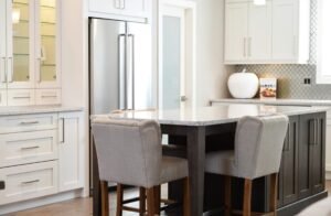 Modern kitchen featuring a sleek, stainless steel smart refrigerator with a double-door design, blending seamlessly with minimalist white cabinetry and a stylish marble countertop.