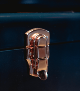 Close-up of a shiny metal latch or clasp on a dark surface.
