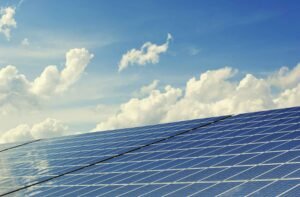 Solar panels under a bright blue sky, capturing renewable energy to provide clean, sustainable power for homes and businesses.