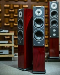 High-end floor-standing audio speakers with mahogany cabinets and multiple drivers displayed in an audio equipment showroom