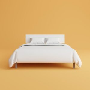 Modern white bed with pillows on a bright yellow background for mattress selection guide.