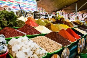 Colorful piles of spices displayed in a busy market setting.