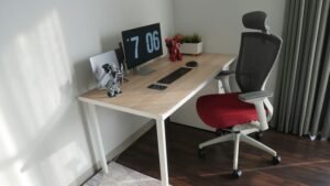 Clean home office desk setup featuring a red ergonomic chair and a computer