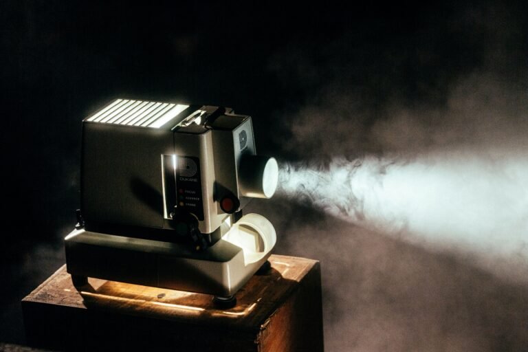 Old-fashioned film projector emitting a beam of light in a dark room