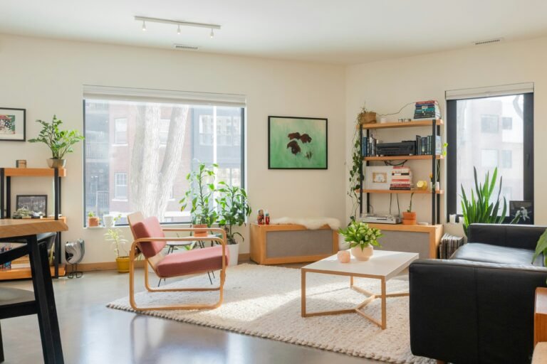 Well-lit living area filled with houseplants and modern seating.
