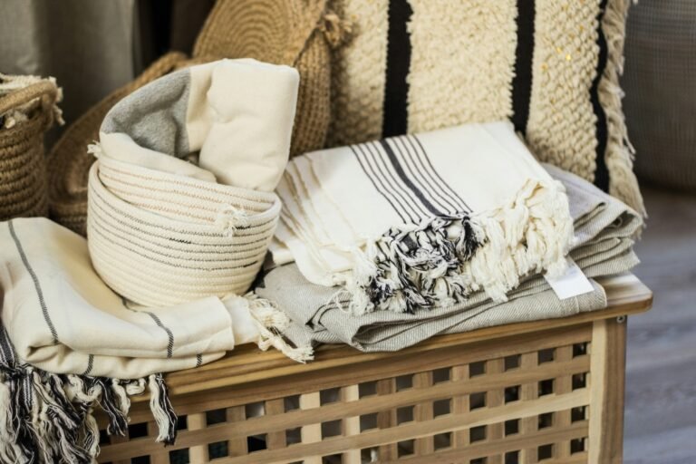 Wicker hamper filled with cozy pillows and soft blankets.