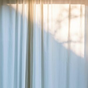 Cream-colored curtains softly illuminated by natural light