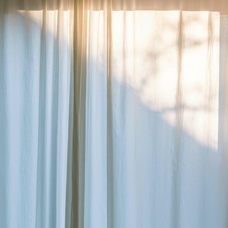 Cream-colored curtains softly illuminated by natural light