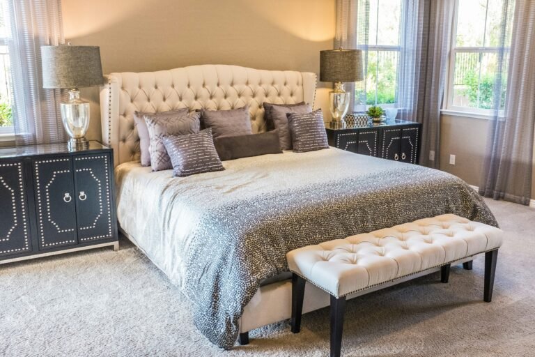 Comfortable bedroom featuring a tufted bed, soft linens, and side tables.