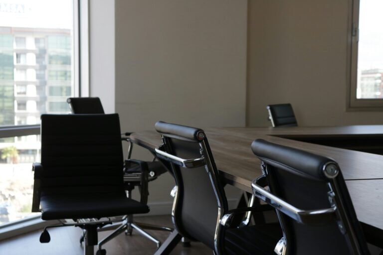 Row of ergonomic black office chairs around a conference table.