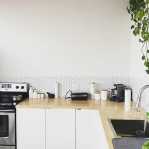 White minimalist kitchen with upper cabinets and a tiled backsplash