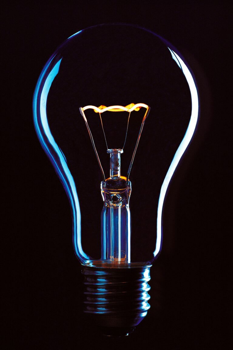 Lit light bulb against a black background.