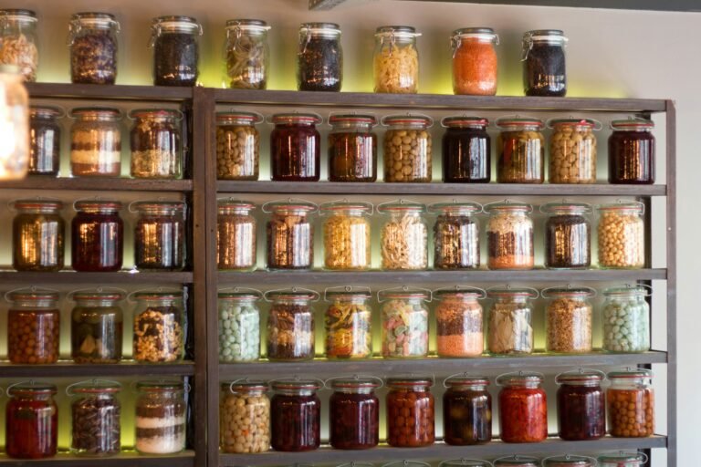 Shelves stacked with a variety of glass jars containing preserved foods.