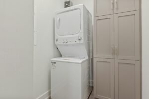 White stacked washer and dryer unit.