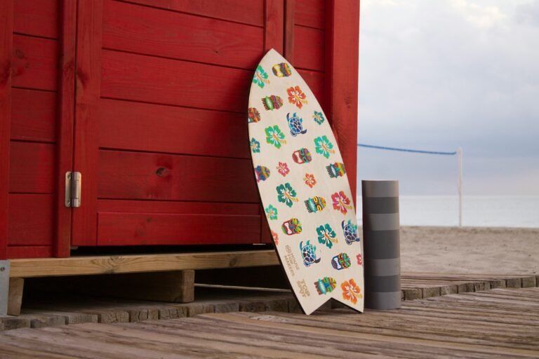Patterned surfboard propped against a bright red shipping container.