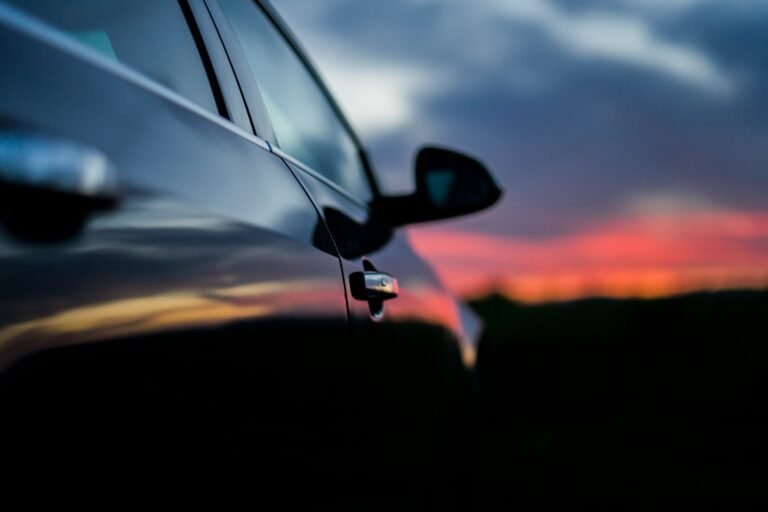 Black car side mirror and sunset reflection