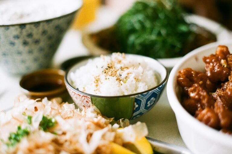 Delicious bowl of rice with savory side dishes in small bowls.