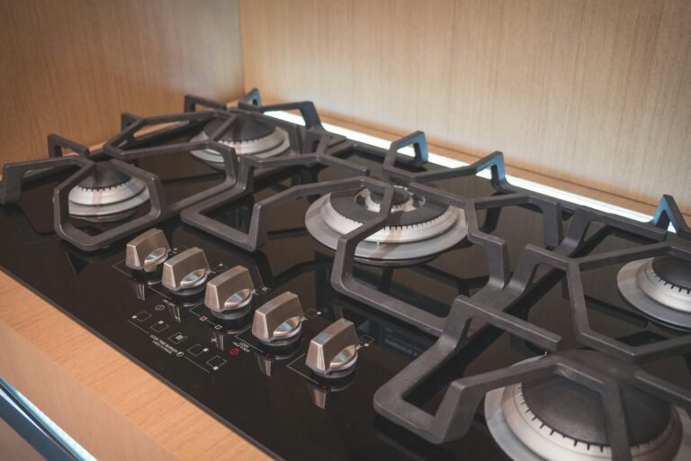 Stainless-steel gas cooktop featuring four burners.