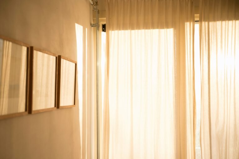 Sheer curtains softly backlit by natural light in a quiet hallway.