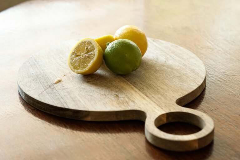 Round wooden cutting board holding sliced lemons.