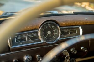 Vintage steering wheel and dashboard of a classic car.