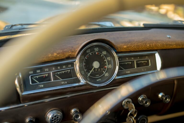 Vintage steering wheel and dashboard of a classic car.