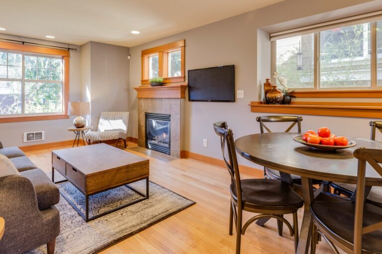Open-concept living area showcasing a warm fireplace and modern furnishings.