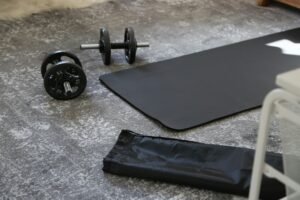Dumbbells and exercise mat laid out in a home gym space.