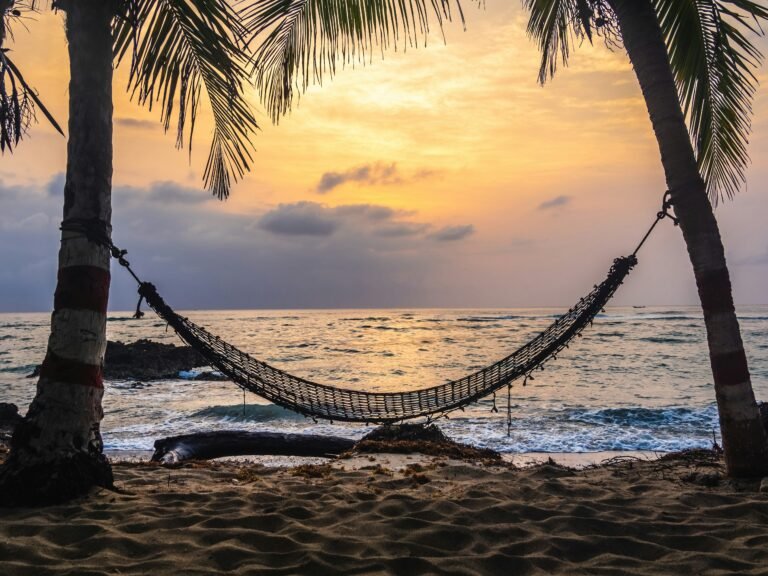 Relaxing hammock on a tropical beach at dusk.