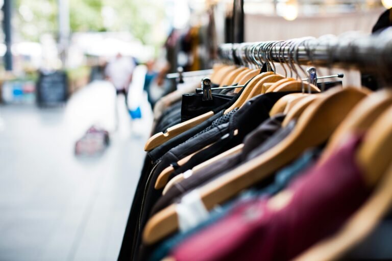 Selection of various clothes hanging on a rack in a shop.