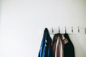 Simple wall-mounted coat rack holding jackets.