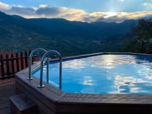 An outdoor hot tub overlooking a valley at sunset