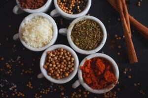 Assorted spices in white ramekins on a light background.