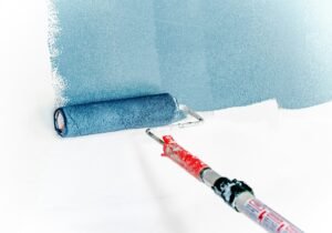 Paint roller coated in a pastel blue shade, ready for application.
