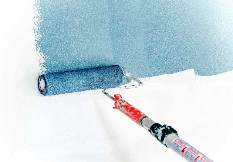 Paint roller coated in a pastel blue shade, ready for application.
