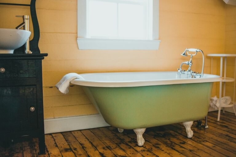 Freestanding green bathtub in a retro-inspired bathroom.