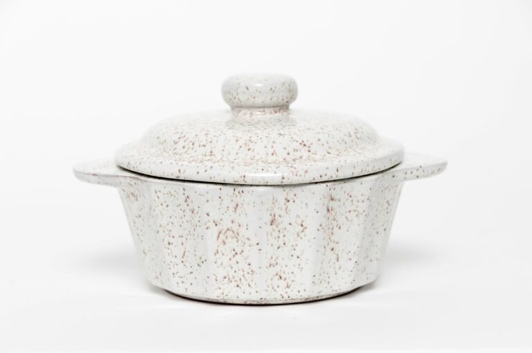 Speckled ceramic lidded pot with a simple, handcrafted style.