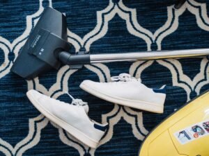 Pair of casual shoes and virtual reality gear on a decorative rug.