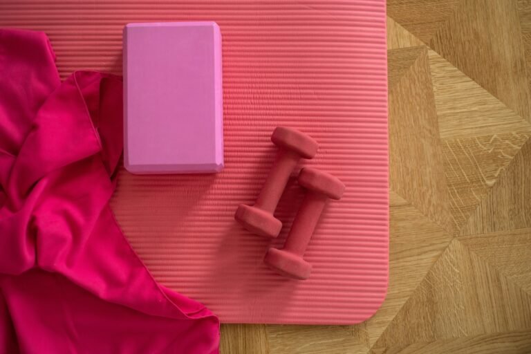 Rolled-out yoga mat topped with small hand weights.