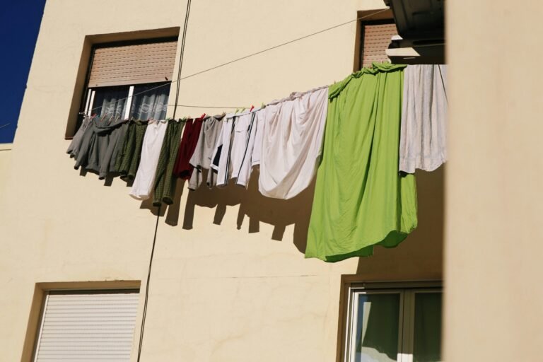 Colorful garments hanging on a line outside a residential balcony