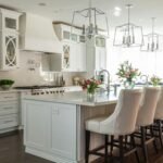 Modern kitchen remodel with white cabinets, large island, pendant lights, and natural daylight