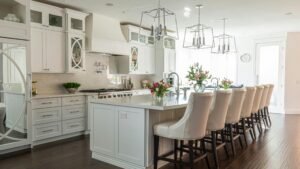 Modern kitchen remodel with white cabinets, large island, pendant lights, and natural daylight